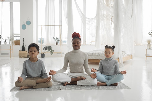 personal development depicted by woman and two children in meditative pose